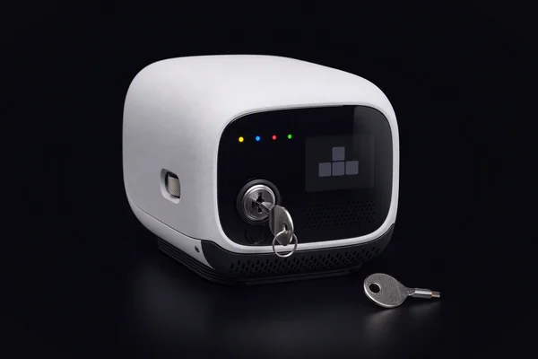 A small compute node with a key in its front lock and a second key lying beside it